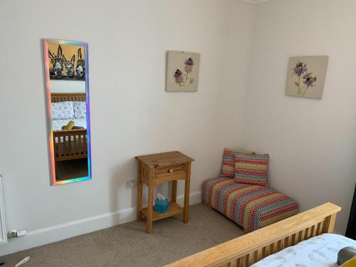 a bedroom with a chair and a mirror at No 7 Quiet, two bedroom Ground Floor Flat in Tornagrain Great for early Airport departures or late flights in Dalcross