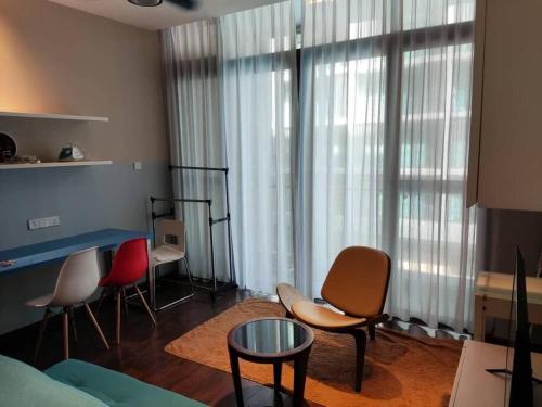 a living room with chairs and a table and large window at 小熊猫亚庇沙巴市区 Little Panda Riverson Imago Kota Kinabalu Sabah Free WIFI in Kota Kinabalu