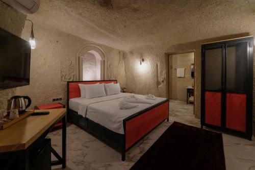 a bedroom with a bed and a desk in a room at The Niche Cave Hotel in Goreme