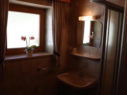 La salle de bains est pourvue d'un lavabo et d'une fenêtre. dans l'établissement Portnerhof auf Oberkirn, à Schenna