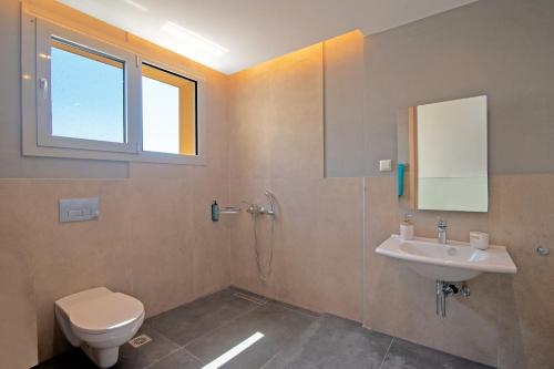 a bathroom with a toilet and a sink at Villa Jasmine Gouvia by Villa Plus in Gouvia