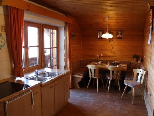 a kitchen with a sink and a table in a room at Portnerhof auf Oberkirn in Schenna