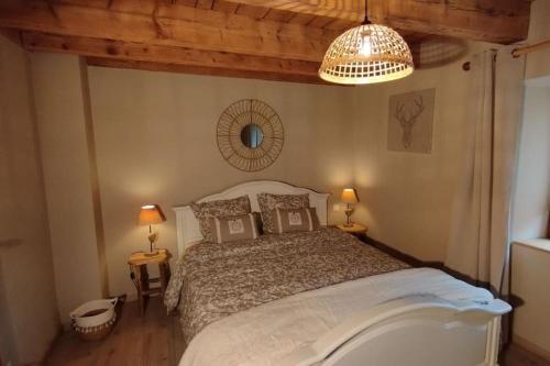 a bedroom with a large bed and a chandelier at Aux balcons de la vallée in Soultzeren
