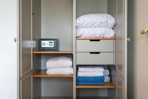 um closet com toalhas brancas e um relógio em Pensiunea Terrablue em Sulina