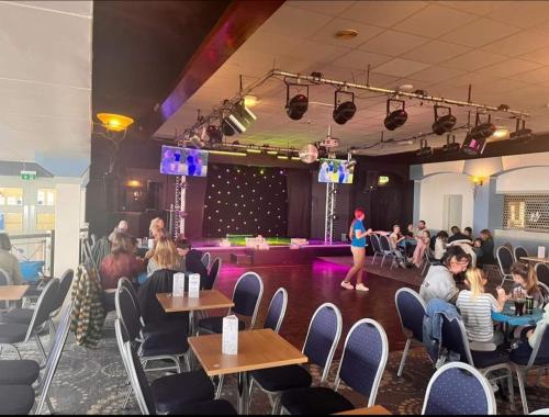 a group of people sitting in a room with a stage at Memories in the making in Paignton