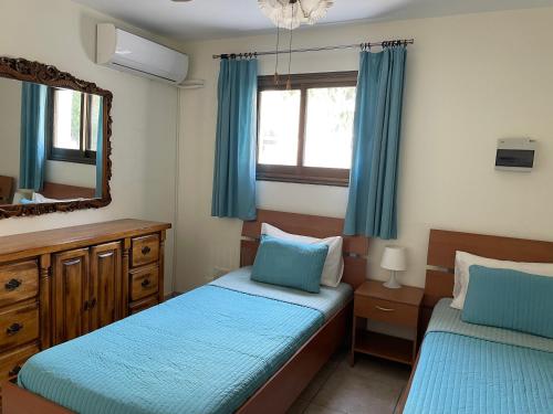a bedroom with two twin beds and a mirror at Villa Kokkinoyia, in Peyia