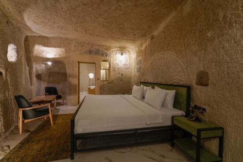 a bedroom with a bed in a stone wall at The Niche Cave Hotel in Goreme