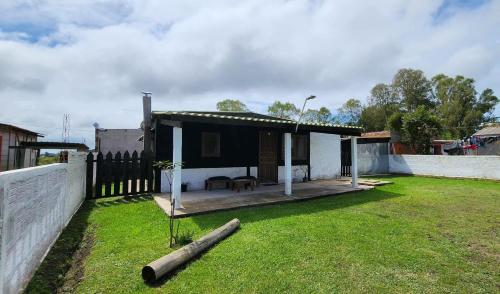 a small house with a porch and a yard at Maridalba in La Coronilla