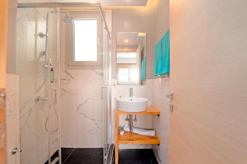 a bathroom with a sink and a shower at Villa Petra Gouvia by Villa Plus in Gouvia