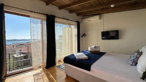 1 dormitorio con cama y ventana grande en Cunda Konak Nazımaki en Ayvalık