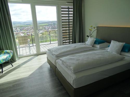 1 dormitorio con 2 camas y ventana grande en Der Florenberg - Gipfel für Genießer en Künzell