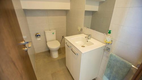 a small bathroom with a toilet and a sink at Villa Sahara Line in Dakhla