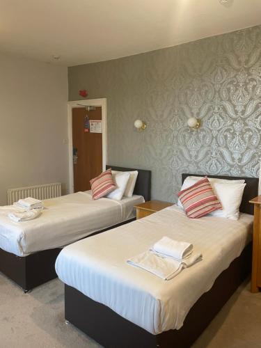 una habitación de hotel con 2 camas en una habitación en Metropole Hotel, en Torquay