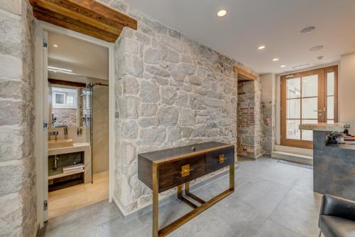 Dispone de baño con pared de piedra y escritorio. en Stonemasons Heritage en Split