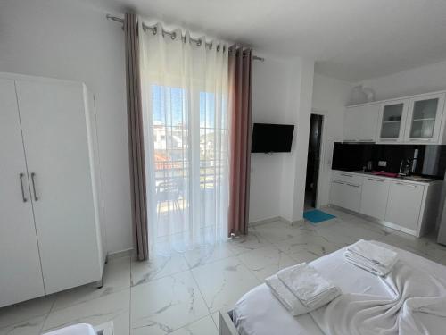 a white room with a bed and a large window at Villa Denis Ksamil in Ksamil