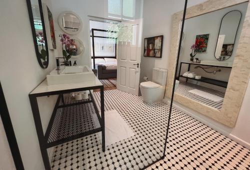 La salle de bains est pourvue d'un lavabo, de toilettes et d'un miroir. dans l'établissement 1 Royal Street Guesthouse, à Riebeek-Kasteel