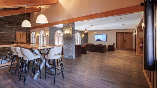 an open living room with a bar with stools at Hôtel Le Labrador in Chamonix-Mont-Blanc