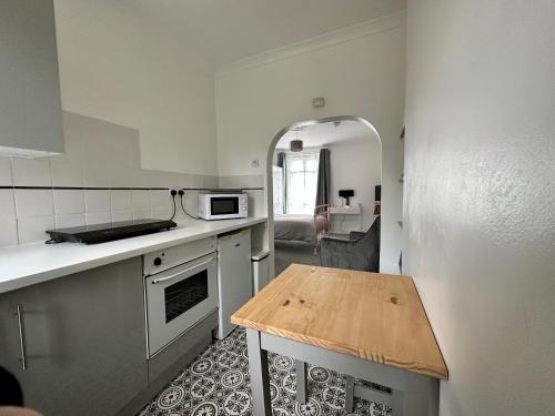 a small kitchen with a table in the corner at Chic & Cosy Studio Apartment in Southampton