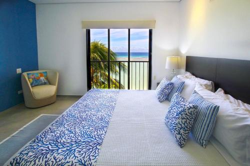 una camera con un grande letto e vista sull'oceano di Beachfront Luxury with Incredible Ocean Views apts a Christ Church