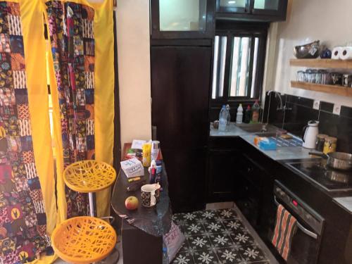 una pequeña cocina con mesa y sillas. en Studio meublé cuisine américaine, en Dakar