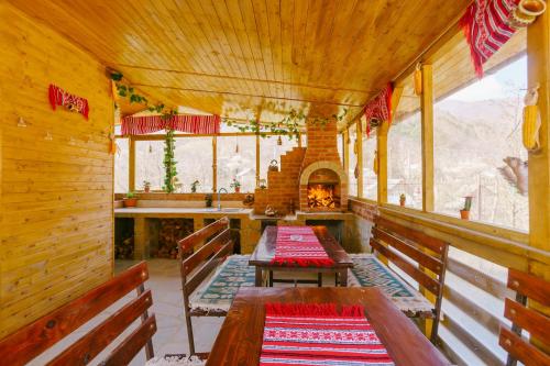 a dining room with two wooden benches and a fireplace at Casa Vio in Nehoiu