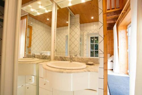 a bathroom with two sinks and a large mirror at Gîte et Roulotte dans les Vosges in Remiremont