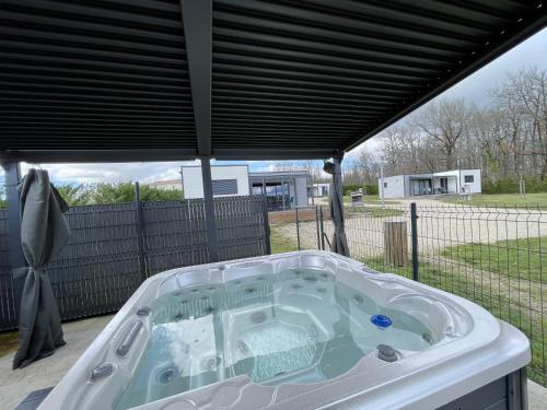 a hot tub on a patio with a roof at Paradis De Bellevue in Puymiclan