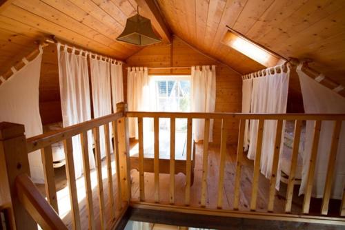 a wooden cabin with a balcony with a window at Gîte et Roulotte dans les Vosges in Remiremont