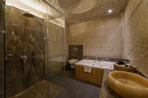 a bathroom with a sink and a shower and a toilet at The Niche Cave Hotel in Goreme