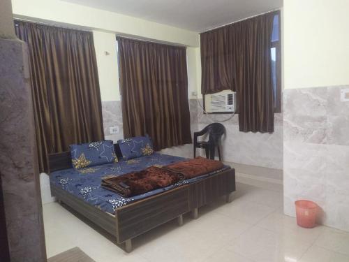 1 dormitorio con 1 cama con sábanas y cortinas azules en Shree Radha Krishna Guest House By WB Inn en Harchandpur