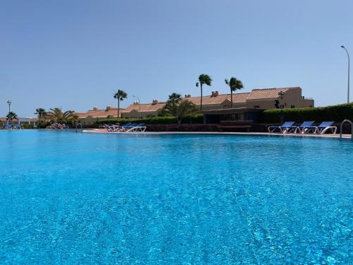 a large swimming pool with blue water at Elegant Colonial Style Ocean View Golf Del Sur in San Miguel de Abona