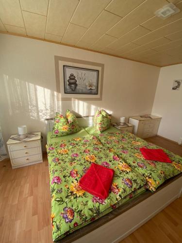 a bedroom with a bed with a green blanket and pillows at FeWo Taucha in Taucha