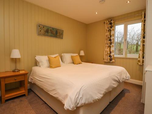 a bedroom with a large white bed and a window at Oak Lodge in Preston