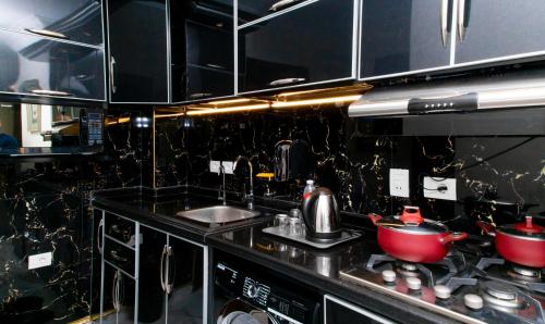 uma cozinha com um lavatório e um fogão com panelas e frigideiras em Porto Said Tourist Resort em `Ezbet Shalabi el-Rûdi