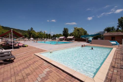 una gran piscina con gente en el agua en Camping Paradis le Rocher de la Granelle en Le Bugue