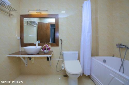 uma casa de banho com um lavatório, um WC e uma banheira em Sumitomo1 serviced apartment & hotel em Hanói