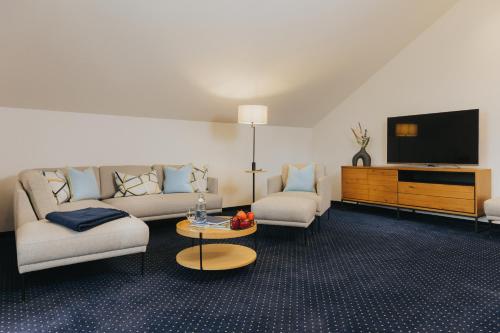 a living room with a couch and a tv at Gutshof Sagmühle in Bad Griesbach