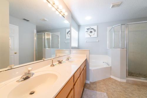 een badkamer met een wastafel, een bad en een spiegel bij 344BONVILLE-Stargazer (B) in Davenport