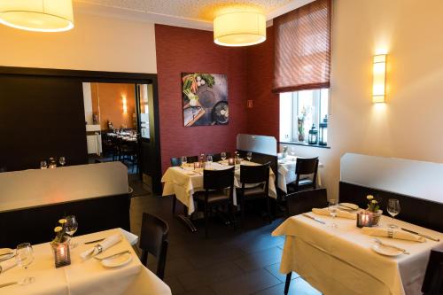 a dining room with tables and chairs in a restaurant at BC Hotel Bad Kreuznach mit Restaurant Mühlentor in Bad Kreuznach