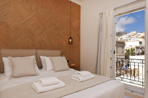a bedroom with a large bed with two towels on it at Natal Suite in Ermoupoli