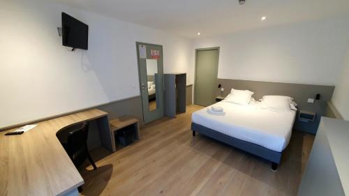 a bedroom with a bed and a tv in a room at Logis Hôtel du Fer à Cheval in Yenne