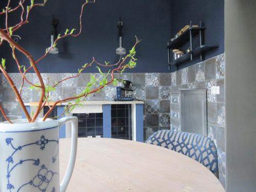 een keuken met een tafel met een vaas met een plant bij Zintuinen in Esbeek