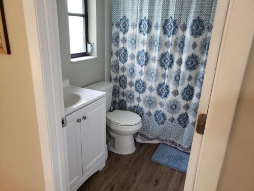a bathroom with a toilet and a shower curtain at Shell near the Sea, 2-Br Pet Friendly Home in Venice