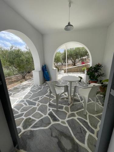 una camera con patio arredato con tavoli e sedie di Kirki Rooms & Studios on the Hill a Paroikia