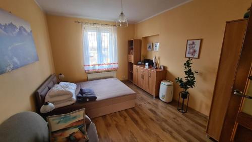 mały pokój z łóżkiem i oknem w obiekcie Apartament Helenka w Supraślu