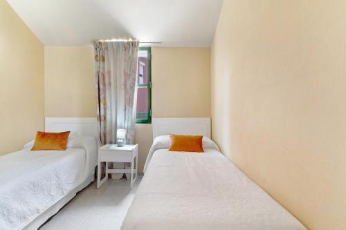 Un dormitorio con dos camas y una ventana. en Colina Verde Maspalomas, en Maspalomas