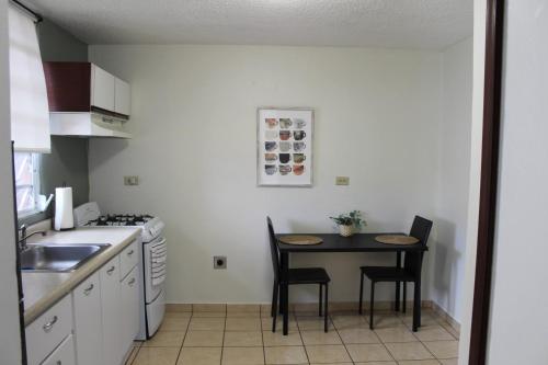 a small kitchen with a table and chairs in it at Marilou Apt A in Levittown