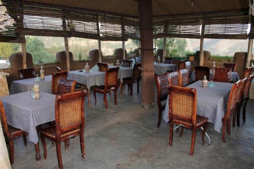 a dining room with tables and chairs in at Lodge Du Chateau in Gonder
