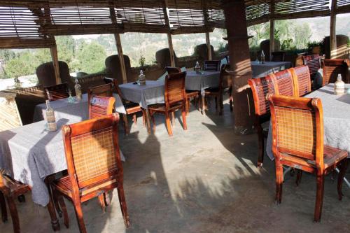 a group of tables and chairs in a restaurant at Lodge Du Chateau in Gonder