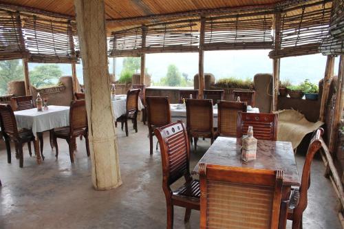 a restaurant with wooden tables and chairs and a table and chairsearcher at Lodge Du Chateau in Gonder